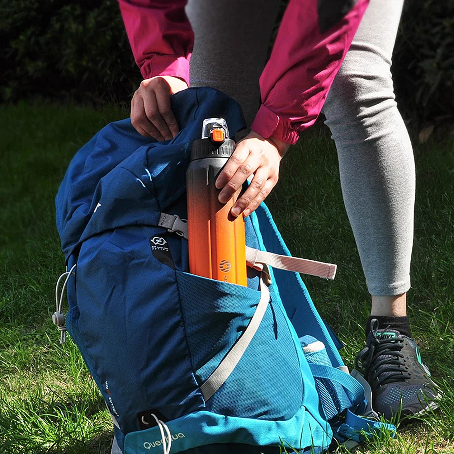 gourde orange et noir dans sac de voyage